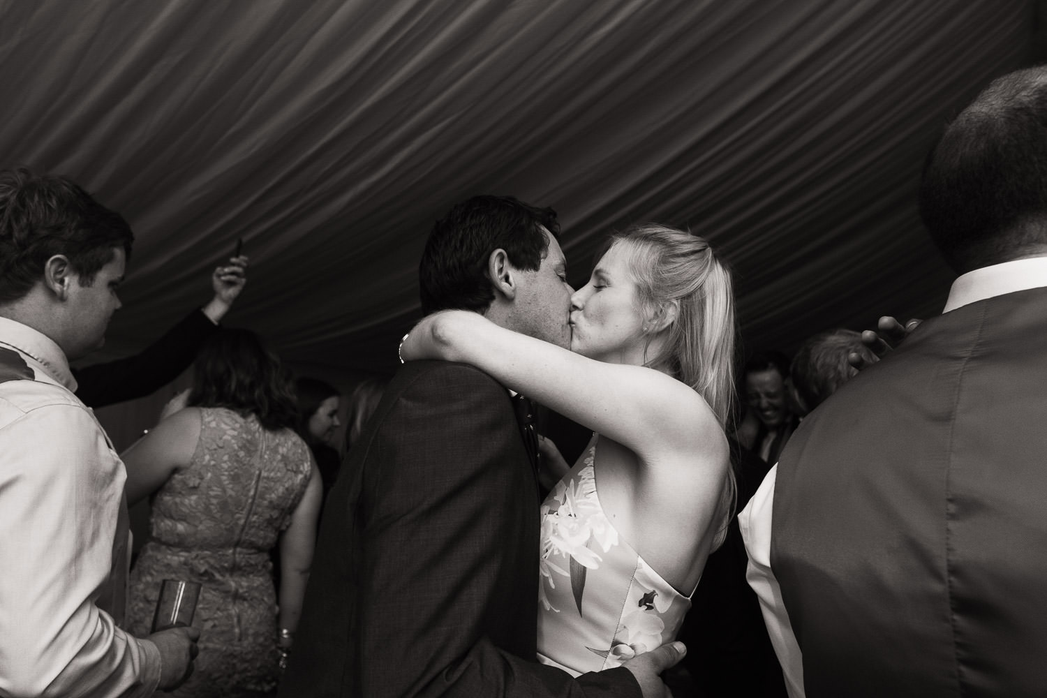 Couple kisses on dancefloor at marquee wedding. Marquee provided by Muddy Boots Marquee.