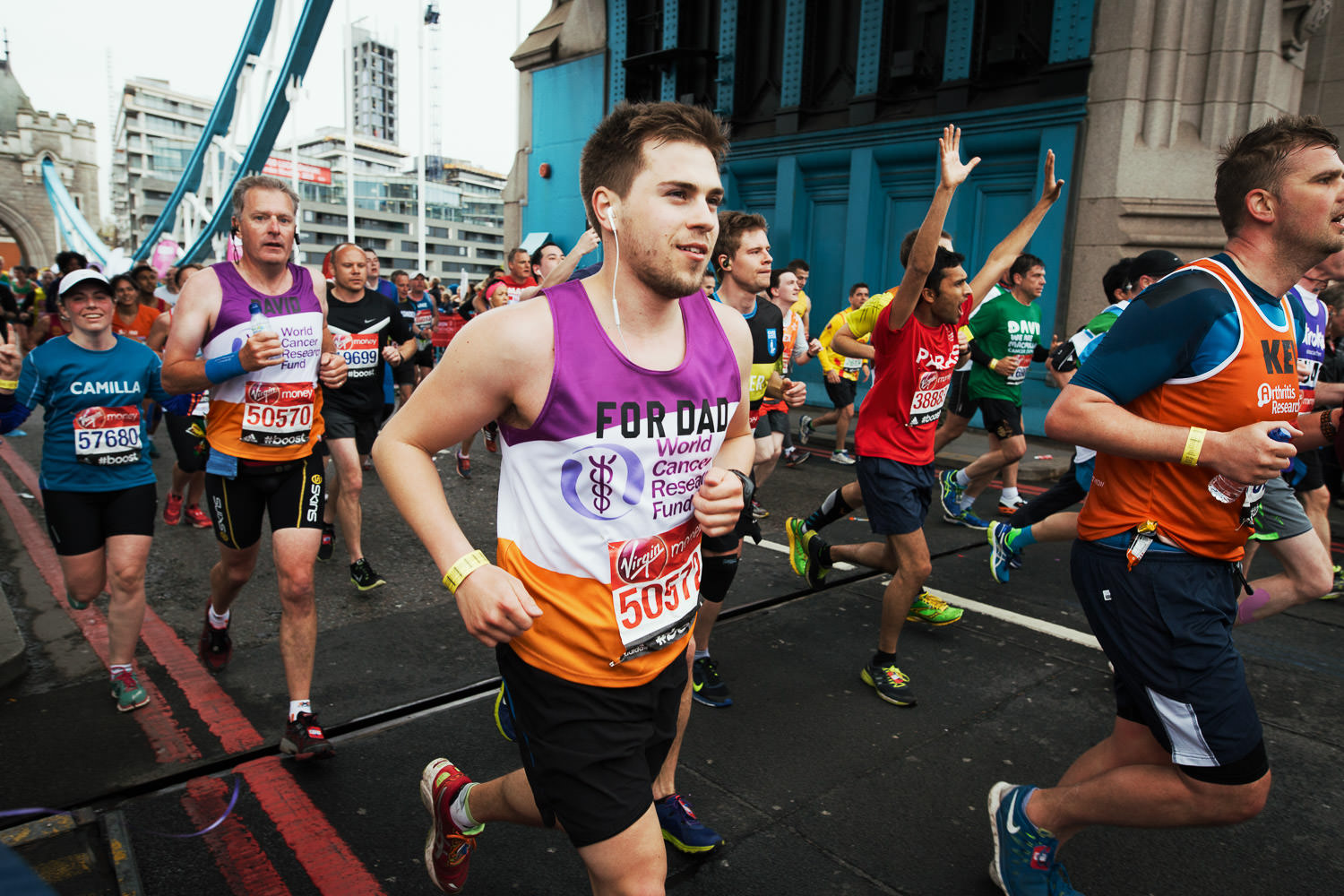 Runners on London Bridge during London Marathon. Runner for the WCRF in the foreground.