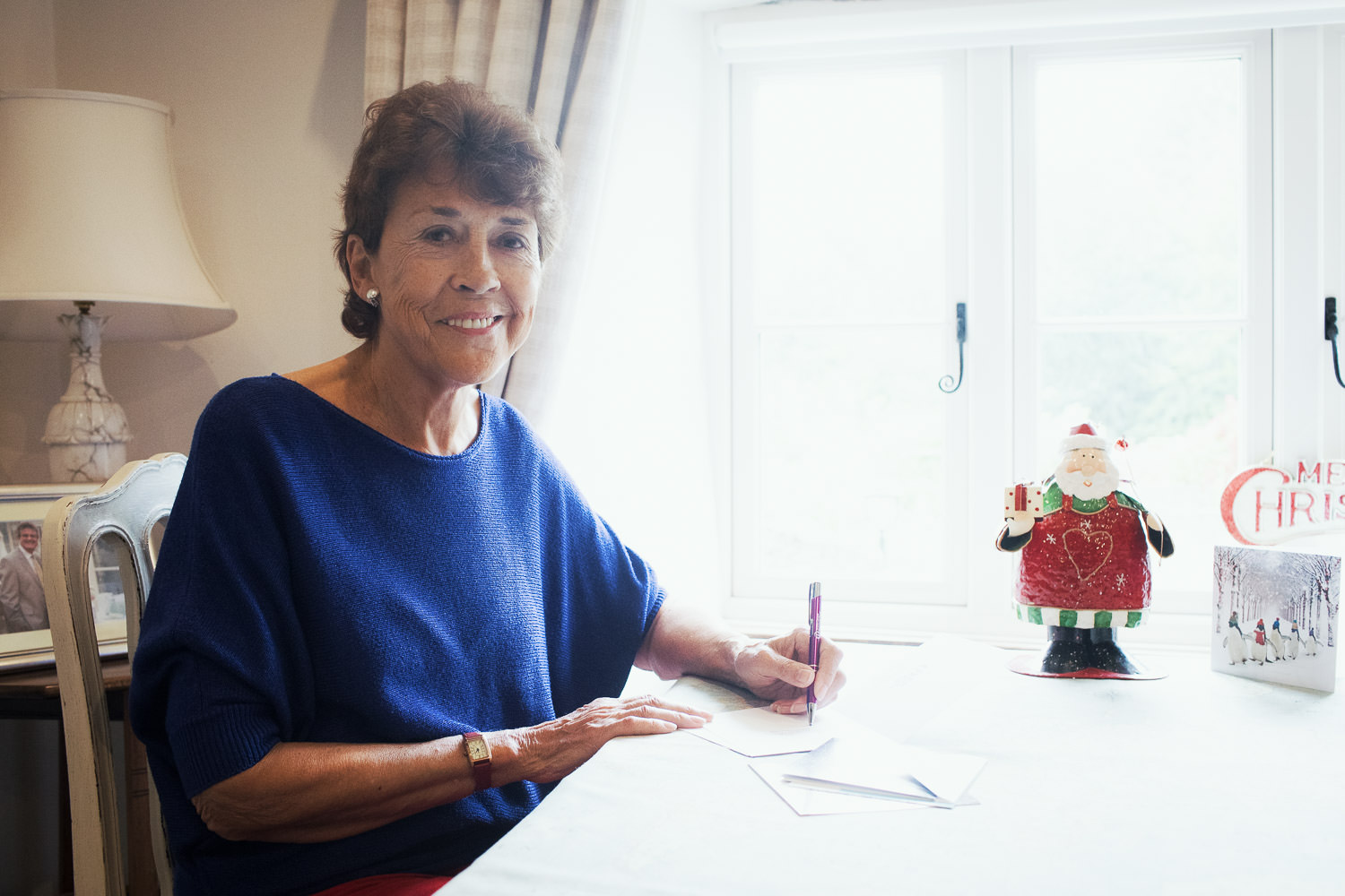 Woman sitting at a table for promotional material.