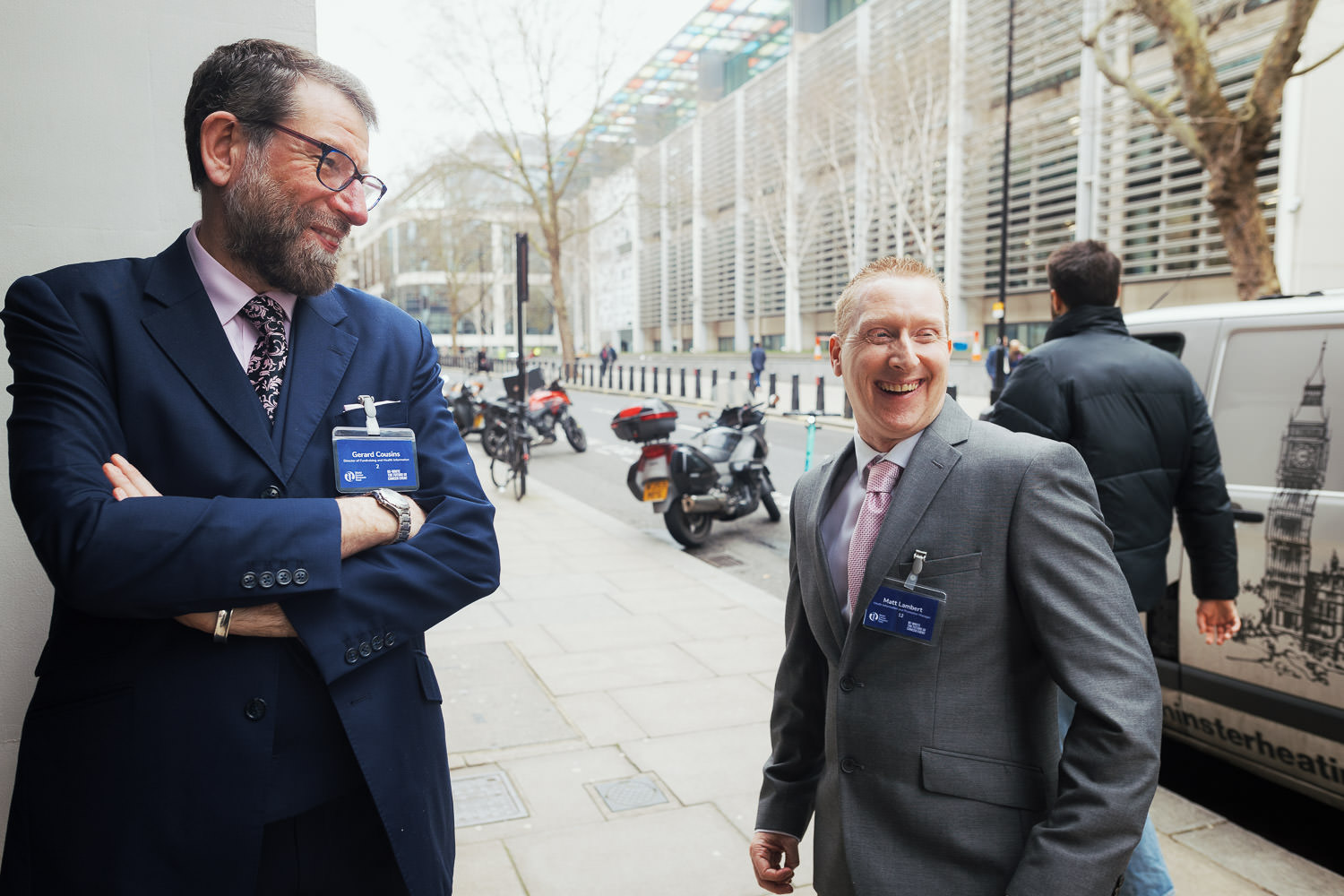 Two people laughing outside a work conference.