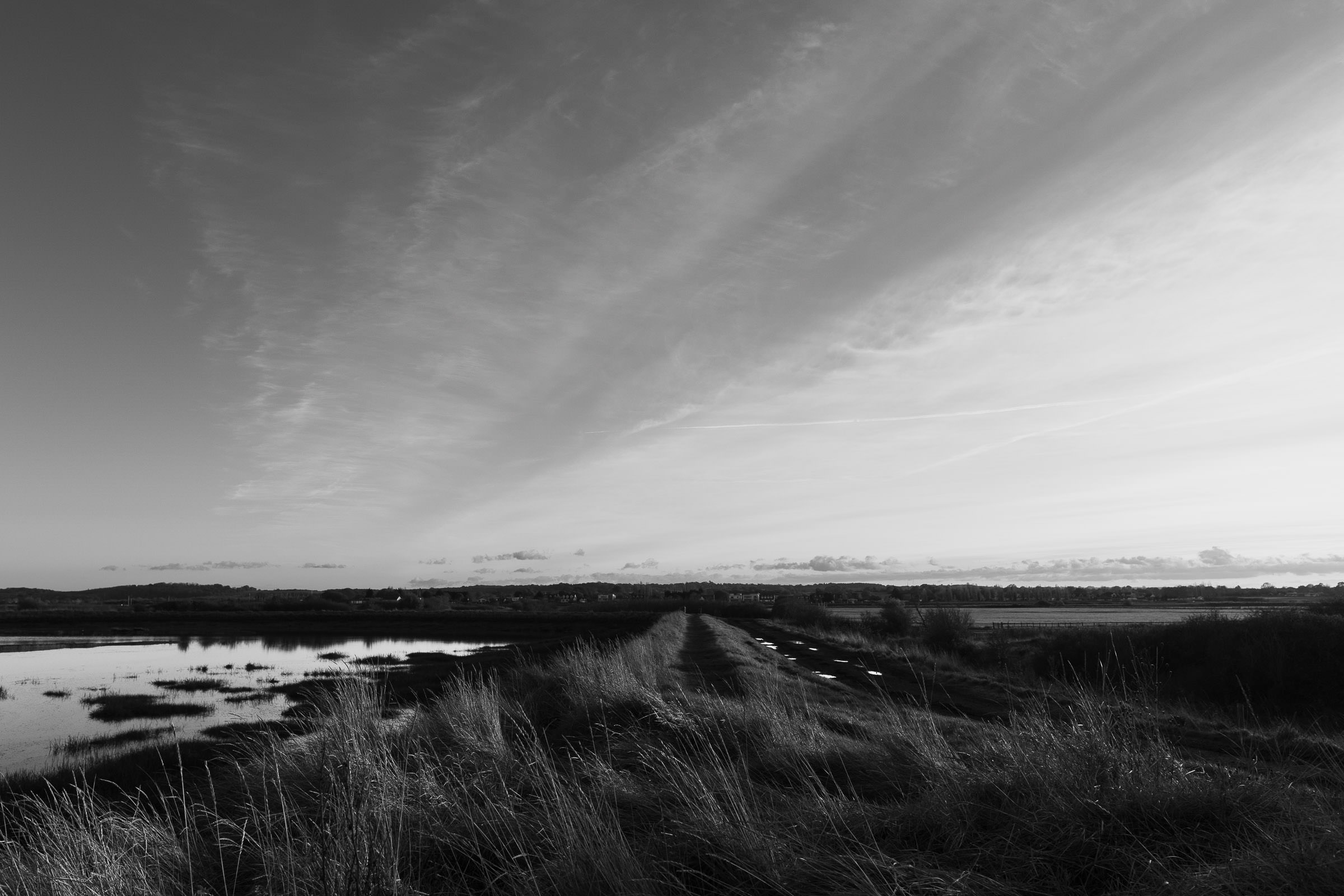 Clements Green Creek, off the River Crouch at Marsh Farm Country Park, is a Site of Special Scientific Interest located in South Woodham Ferrers. This black and white photo, taken in November 2024 by Essex wedding photographer just before sunset. 