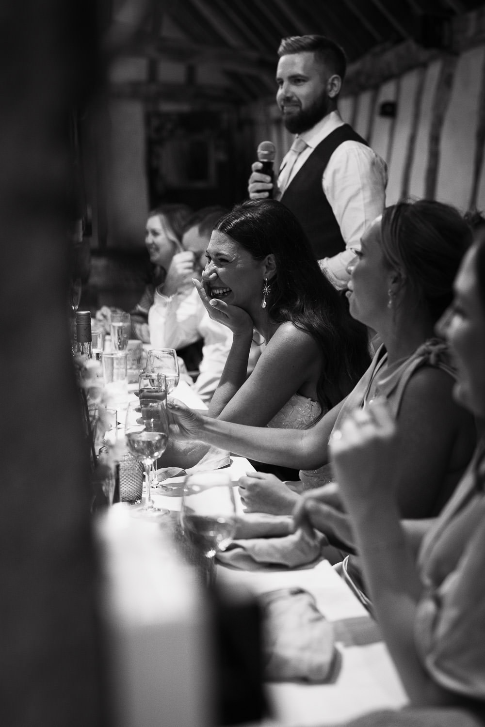 Alpheton Hall Barns Wedding Photographer: Bride covers her mouth as she laughs during her new husband's speech.
At the top table. 