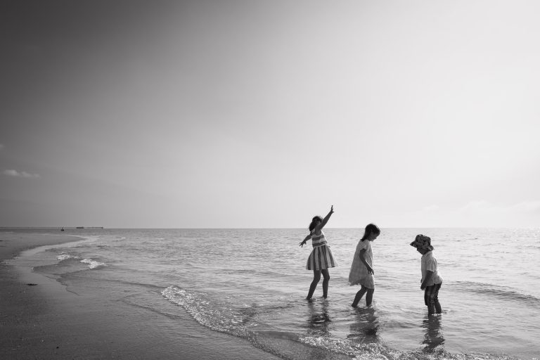 Family moments with my candid and natural photography style. See these three happy children playing on the beach in Frinton, Essex.