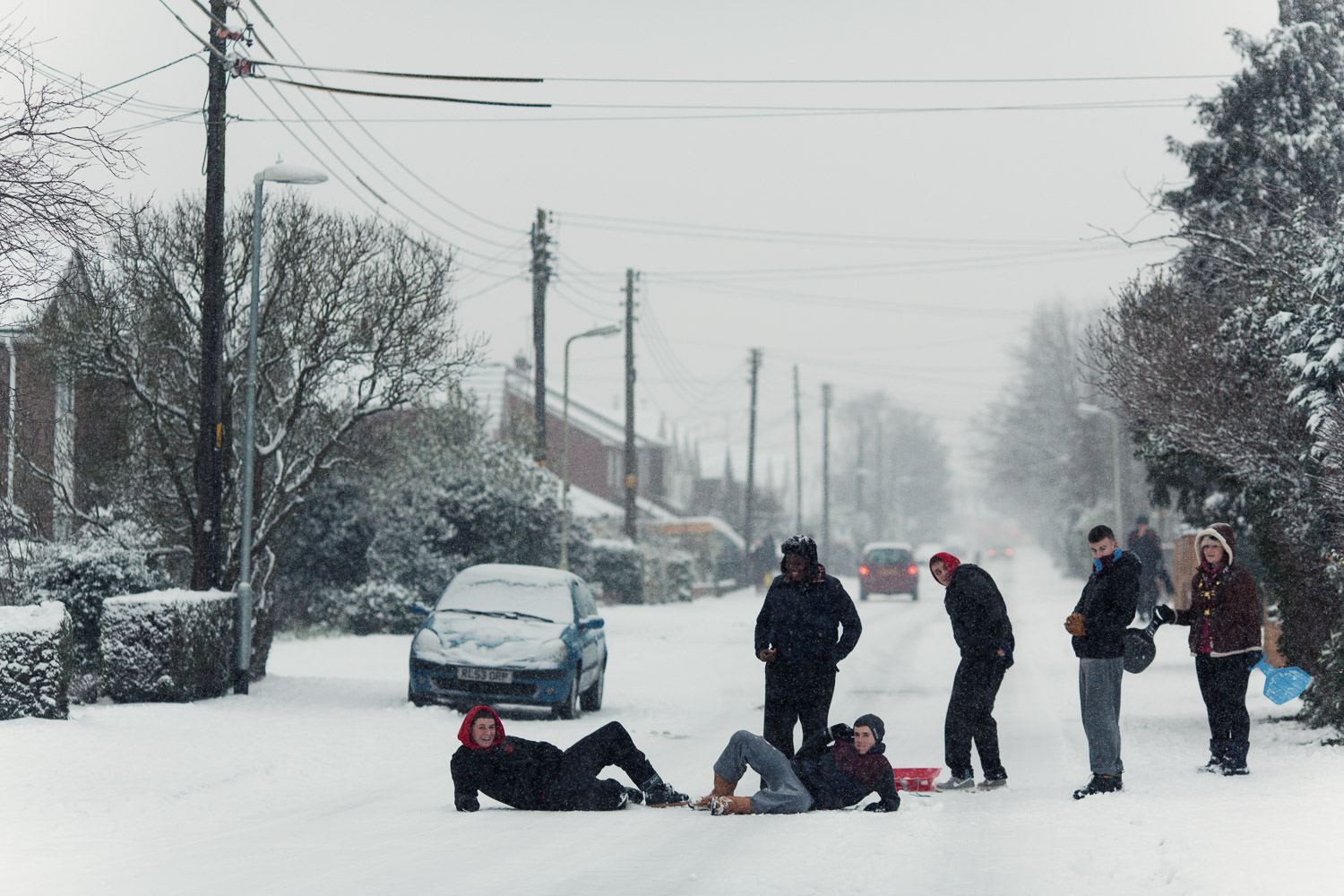 Young people in the middle of the road in the snow. King Edward's Road in South Woodham Ferrers near Chelmsford.