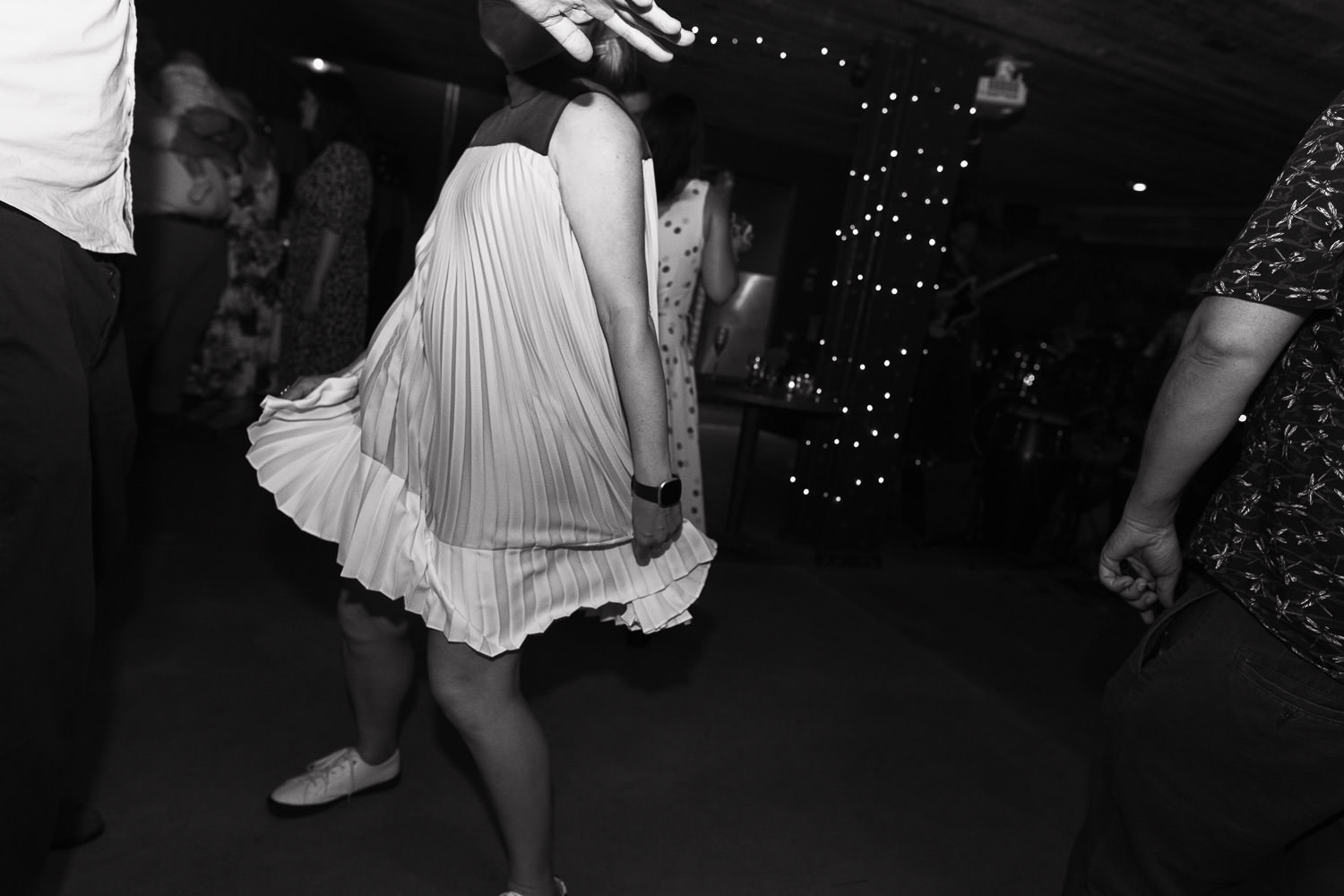 A woman dancing and holding her dress. Wedding reception at Never For Ever in Kentish Town.