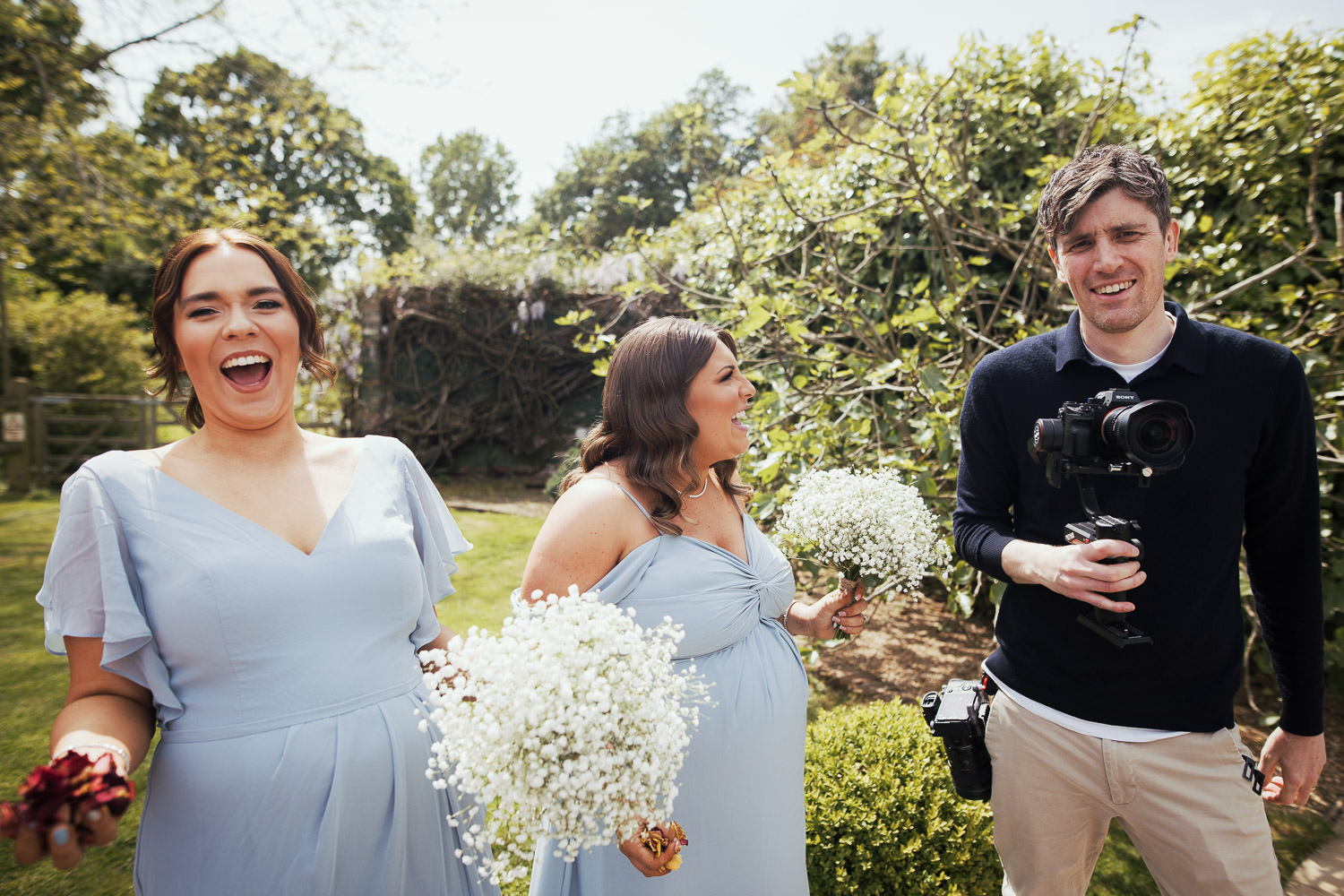 Philip Smith Visuals wedding film maker stood with bridesmaids. They are laughing at him! At Houchins wedding venue.