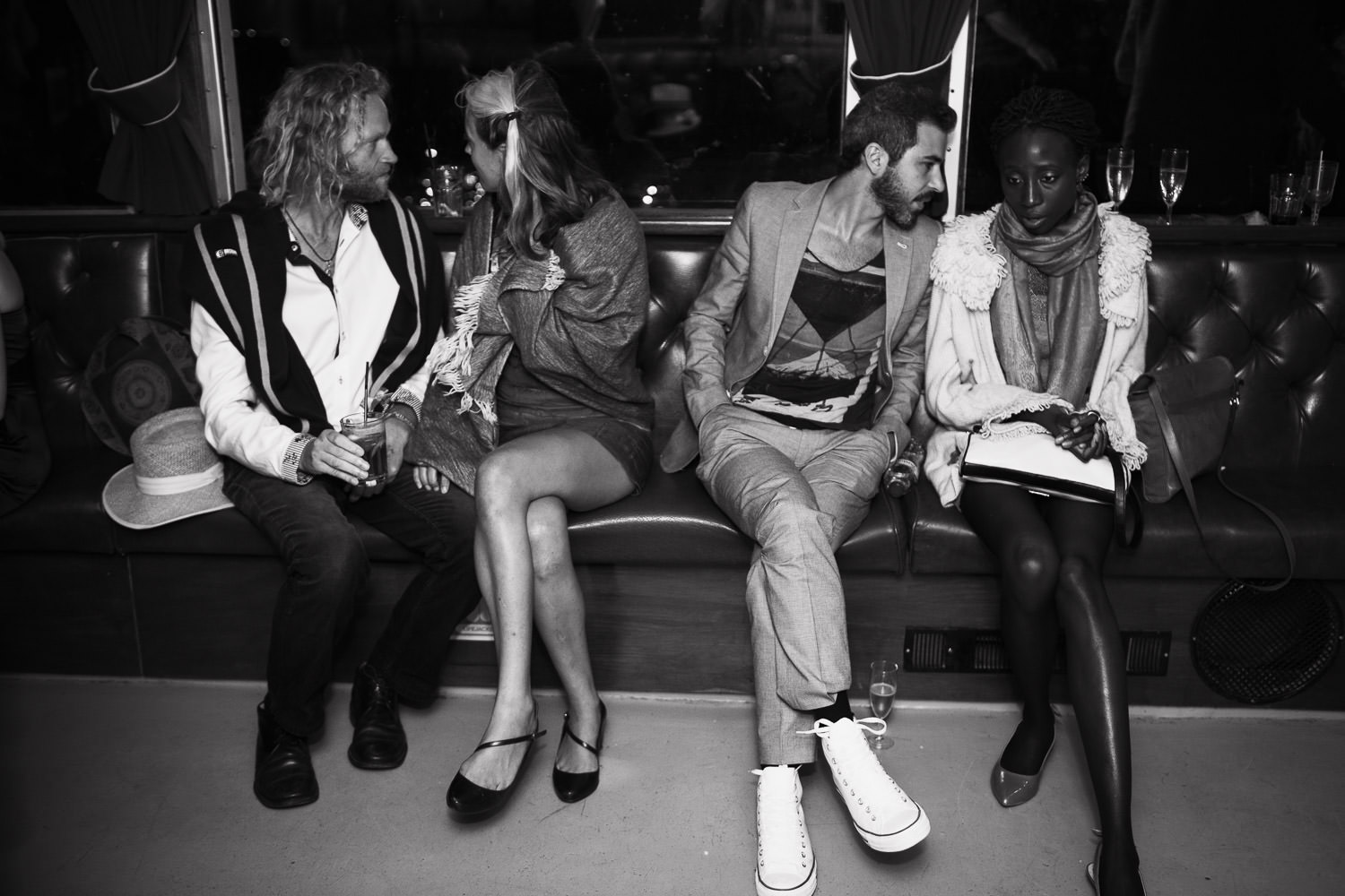 Four people sitting on the padded seats of the Yarmouth Belle at night.