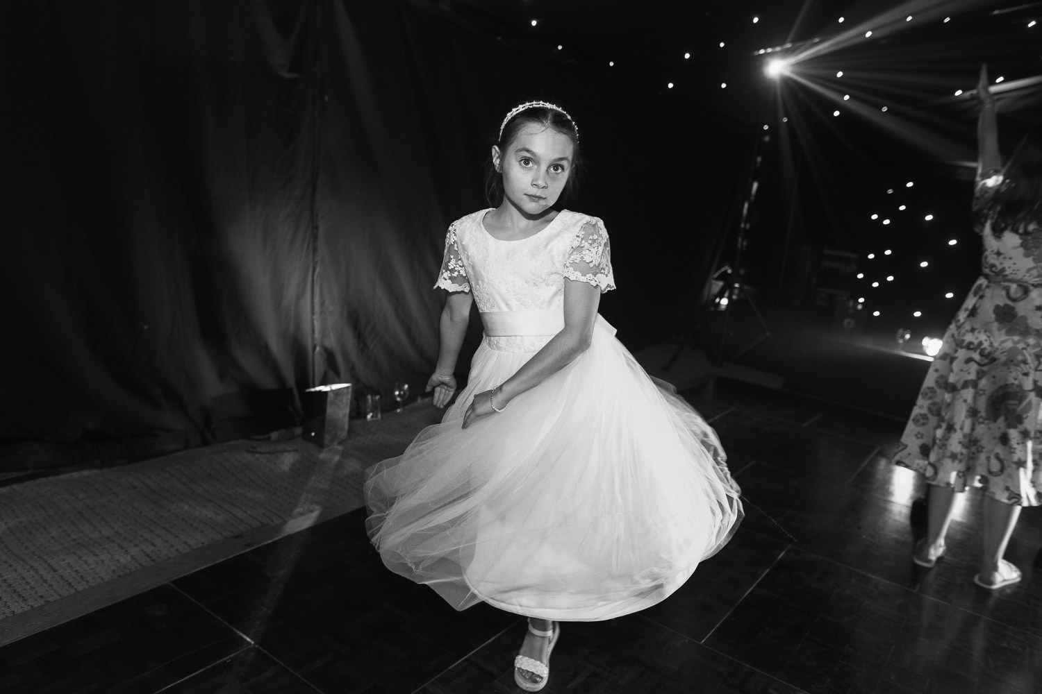 Flower girl swishing dress at wedding reception.