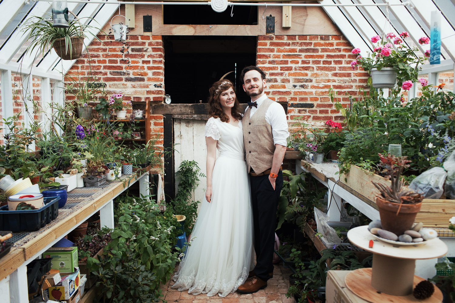 Newly married couple in a Suffolk greenhouse. Garden humanist wedding.