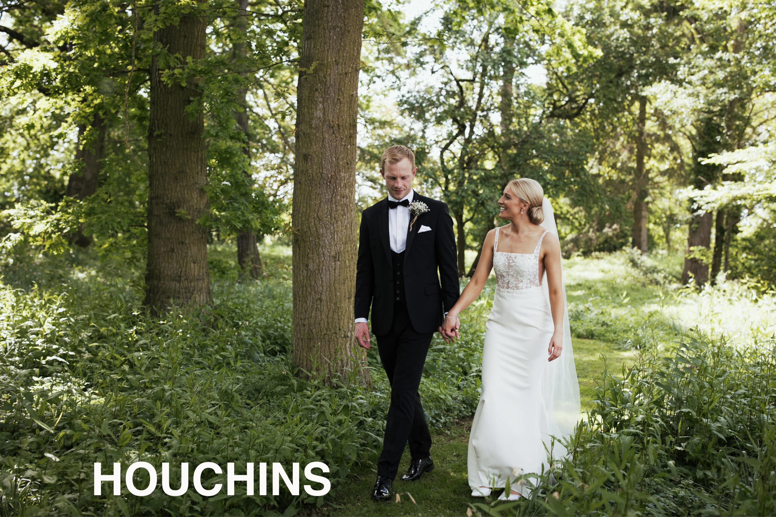 Houchins Wedding Venue: Couple holding hands walking through the woodland area. Groom in black tie suit from The Groom’s Room in Colchester. Bride in ‘Jack’ dress by Made With Love from Halo + Wren Bridal.
Houchin's Lane, Coggeshall, Colchester CO6 1RT