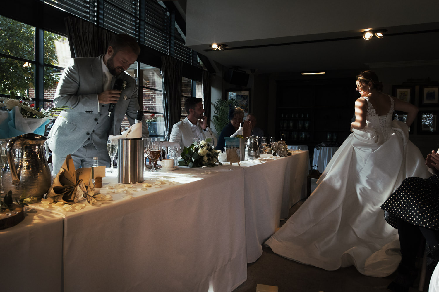 The light through the blinds making stripes on the bride as she walks past the top table. The Lion House in Chelmsford.
Essex wedding venue.