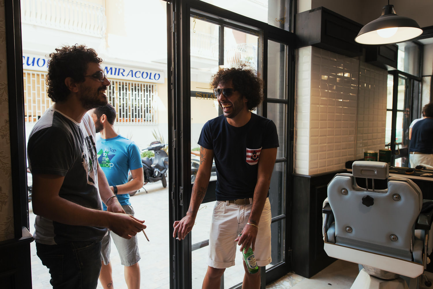 Men smoking in the doorway of Barberia del Centro Agropoli.