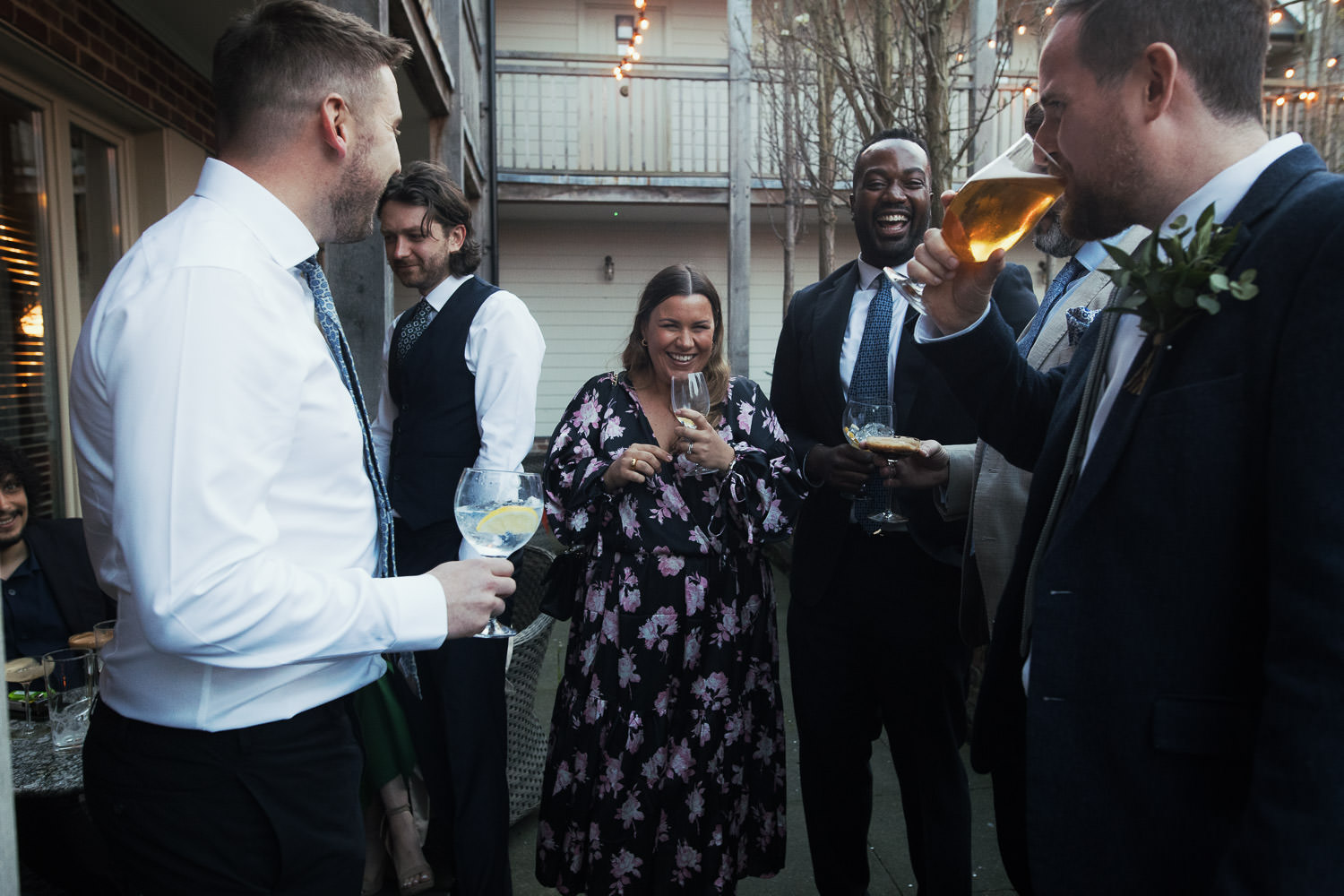 Candid moment of guests enjoying drinks at The Lion House wedding venue in Chelmsford.