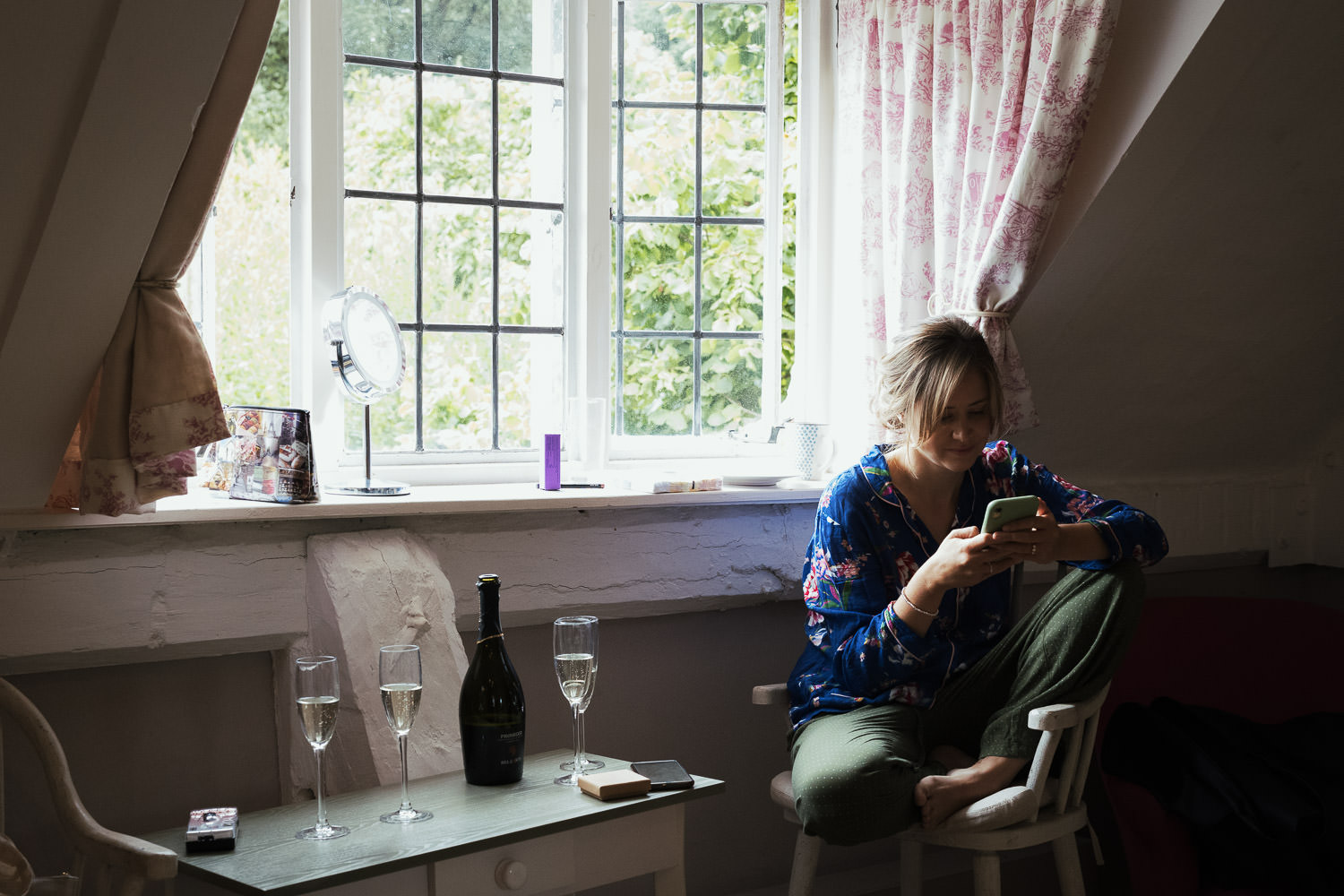 Bridesmaid in pyjamas checking her phone.