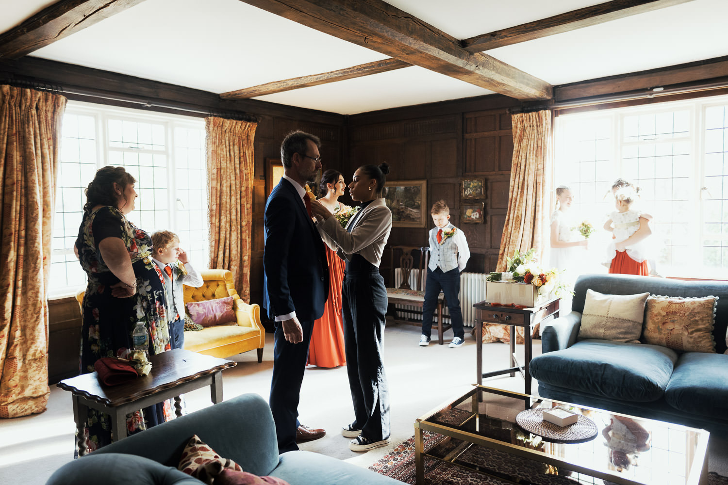 The wedding coordinator at Houchins helps the father of the bride with his buttonhole.