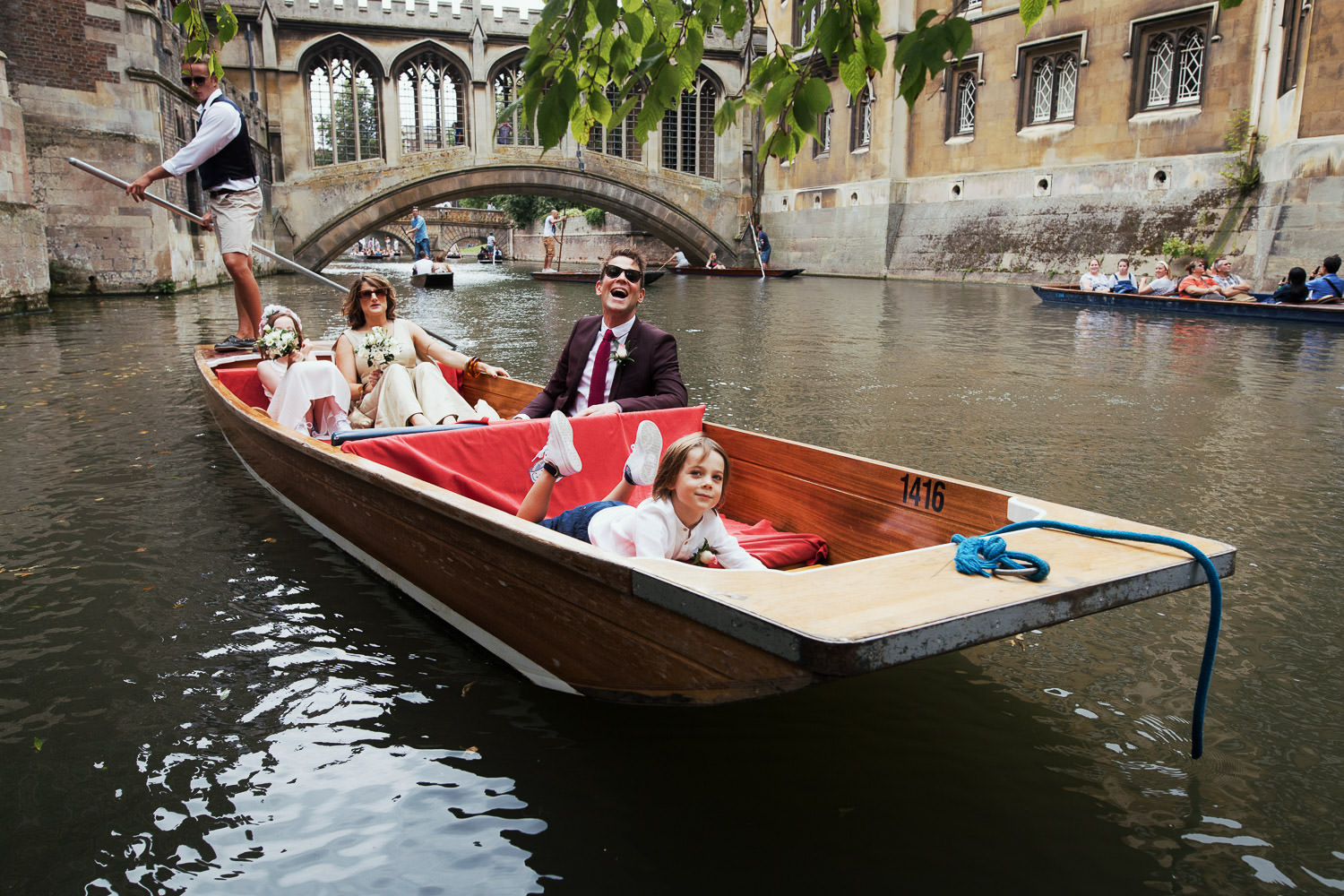 Family on way to wedding in a punt on the River Cam with the Bridge of Sighs in the background