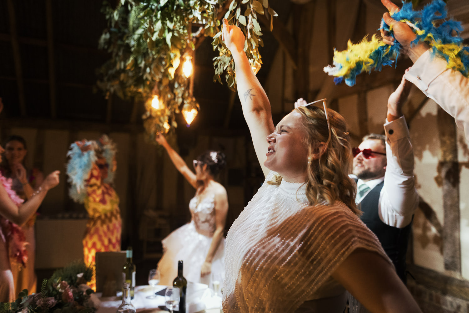 Bride with arm in the air during speeches.