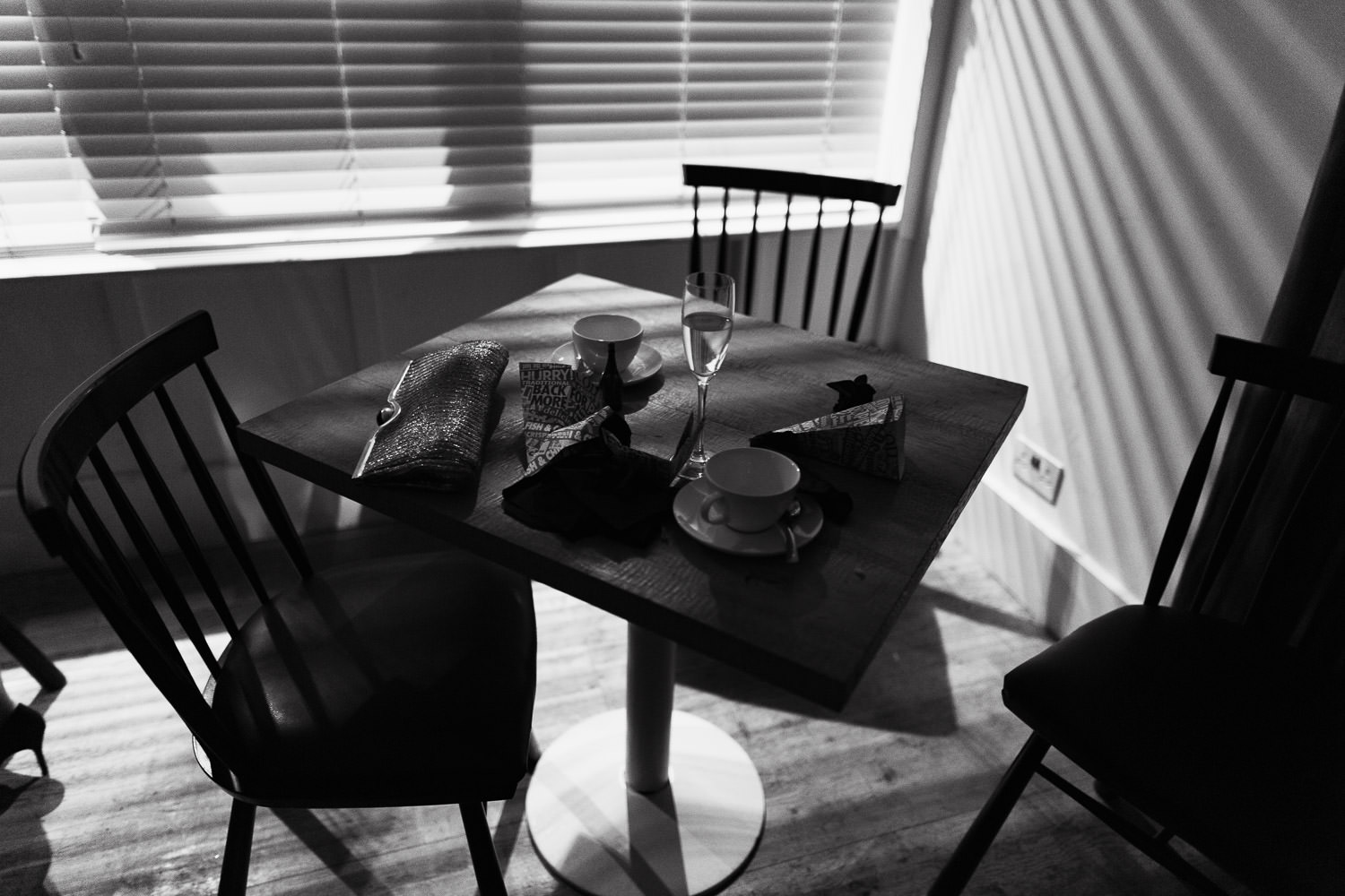 The Gallivant in Rye. A table with cups, handbag, light streams in the blinds. Wedding reception.