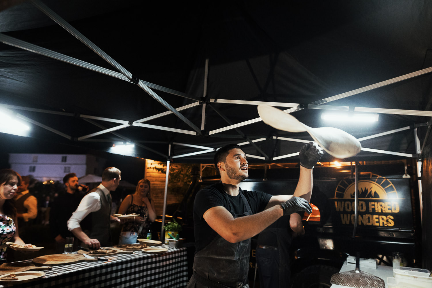 Chef from Wood Fired Wonders tossing pizza dough in the air. Evening food at Houchins.