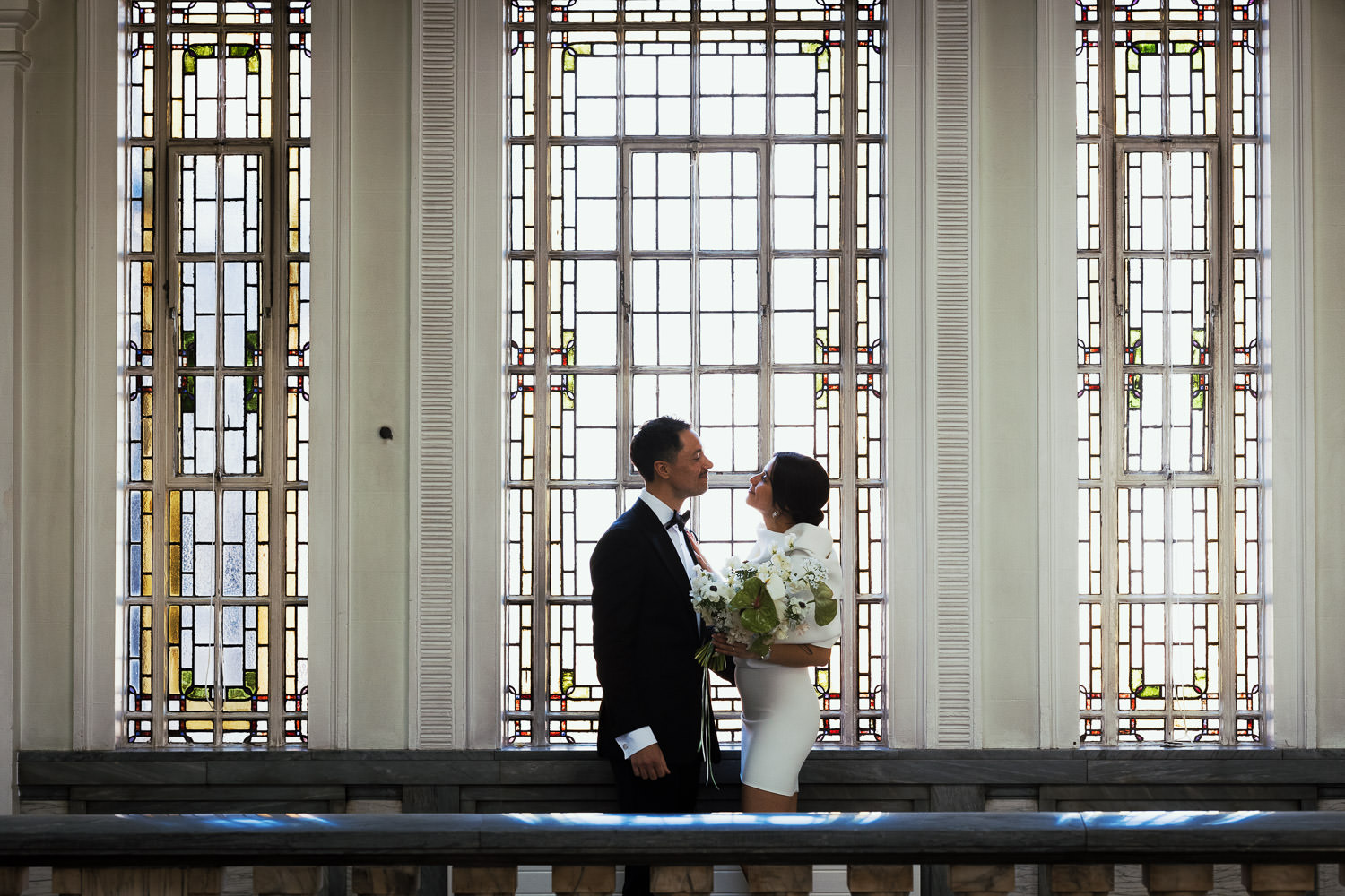 Islington Town Hall Wedding: Newly married couple by the windows on the upper landing.