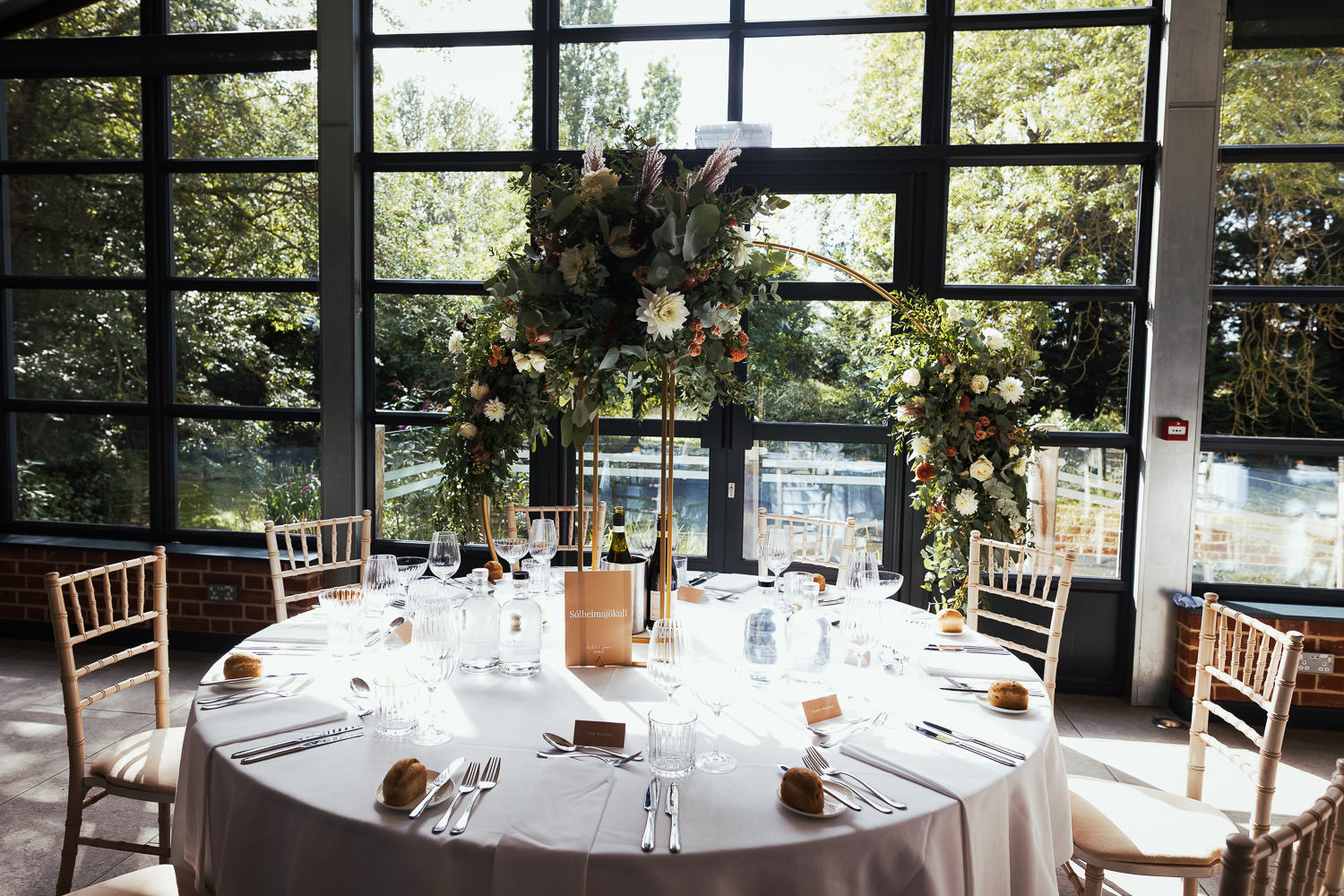 Baddow Park House Orangery: Table set for the wedding breakfast. Flowers by Stock Florist.